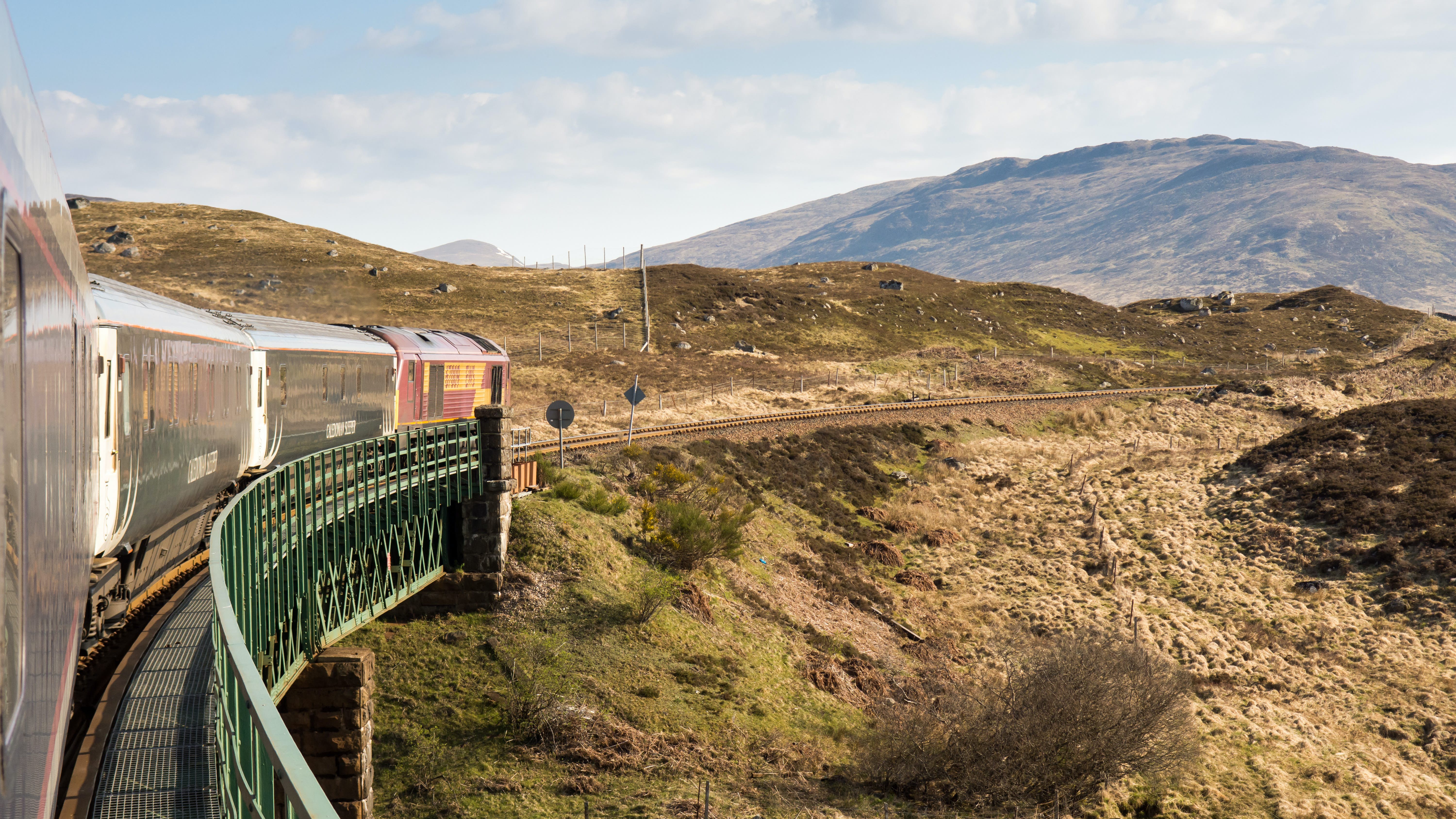 The Caledonian Sleeper train crosses Rannoch Viaduct on the scenic West Highland Line railway in the Scottish Highlands.